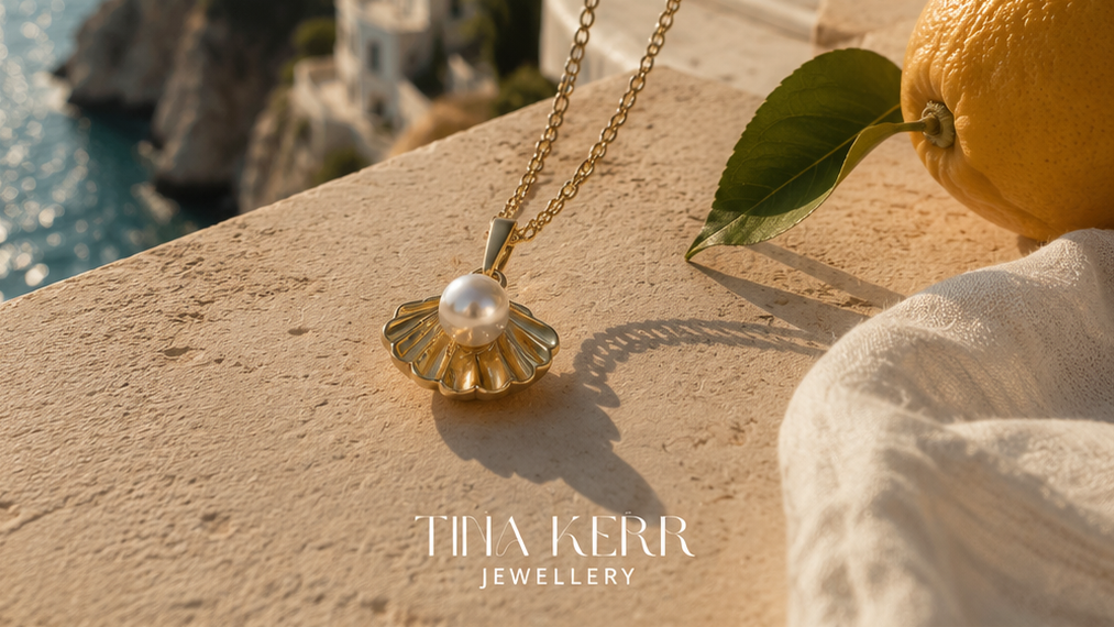 Gold necklace with a pearl pendant on a scenic coastal background, featuring Tilly Kerr Jewellery.