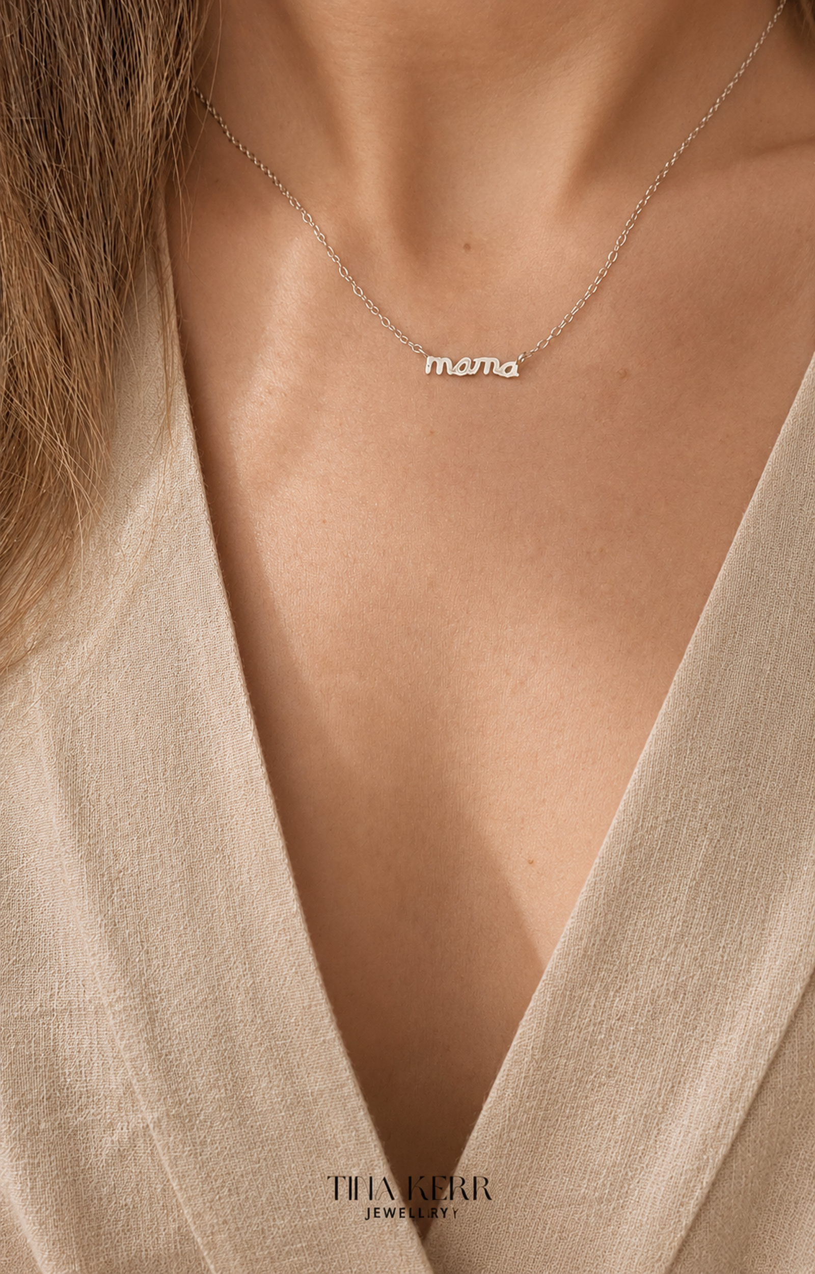 Necklace with 'mama' pendant worn by a person in a beige garment, brand 'THANKKERR' visible.