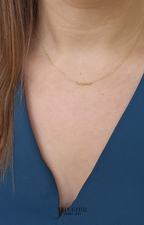Gold necklace on a person wearing a blue top, with 'Bakerr Jewellery' branding.