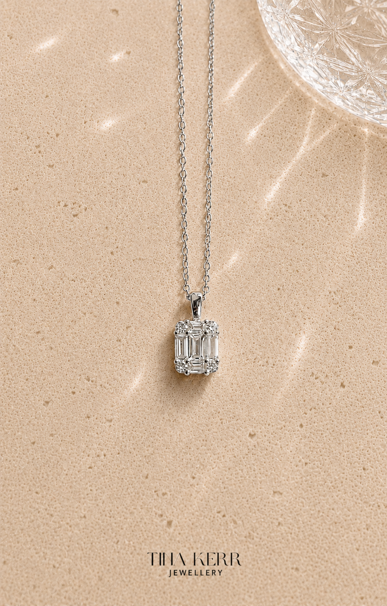 Diamond necklace on a beige surface with 'Thak Kerr Jewellery' branding.